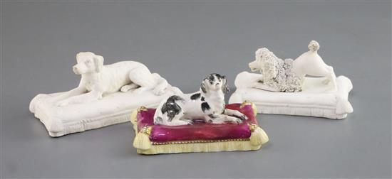 Three Minton porcelain figures of recumbent dogs on tasselled cushions, c.1831-40, L. 10.3cm - 12.2cm, spaniel restored
